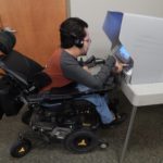 Bill Crowley in his wheelchair using an accessible voting machine